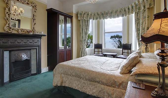 A spacious bedroom with fireplace in Annagh House, Clontarf