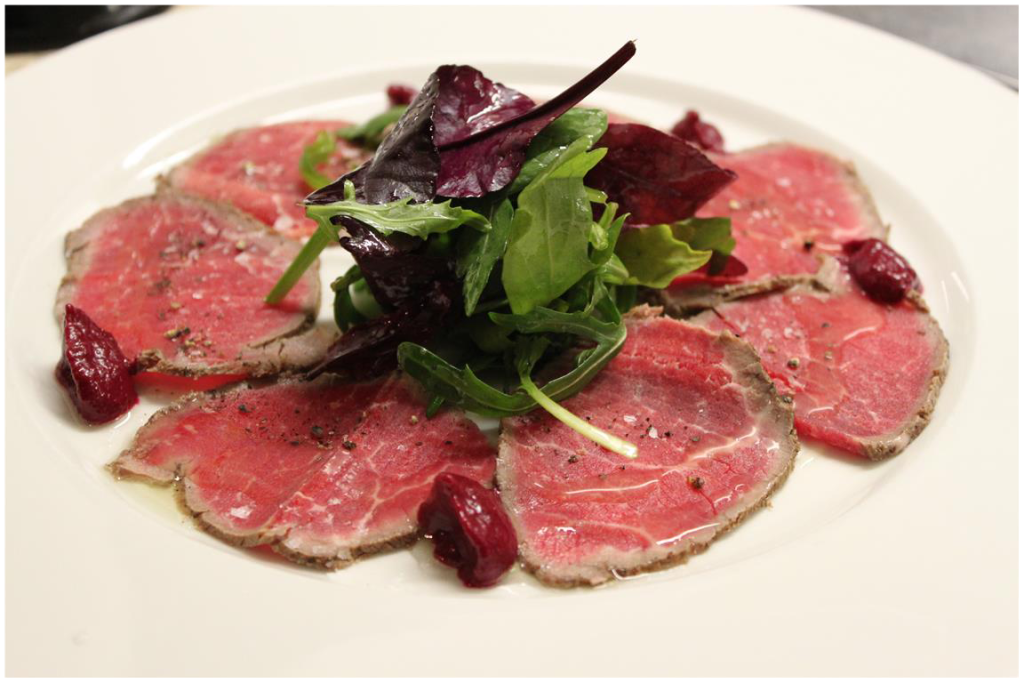 An artfully plated fresh meats and salad in Bloom Brasserie