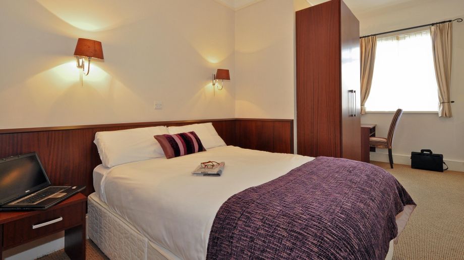 A spacious, presentable double bedroom at Maples House Hotel